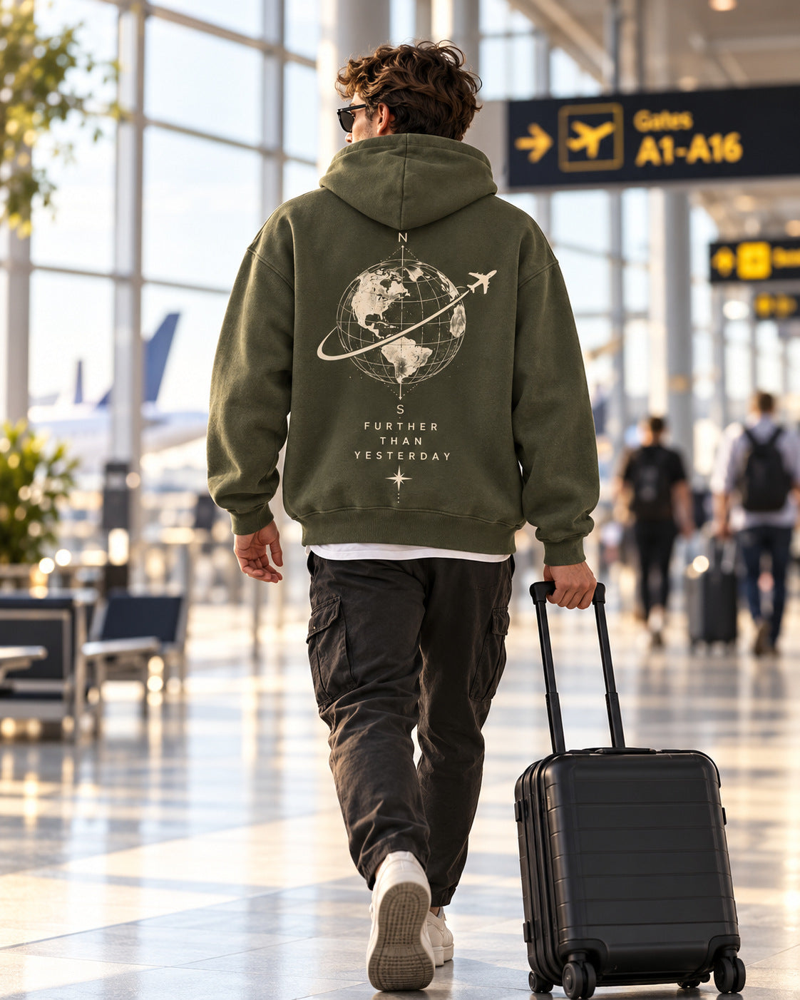Airport lifestyle photo of traveler wearing olive Further Than Yesterday hoodie